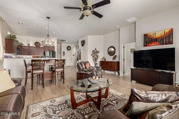 a living room with furniture kitchen view and a flat screen tv