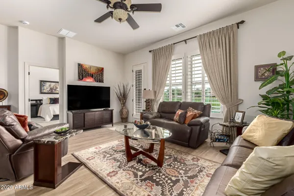 a living room with furniture a flat screen tv and a large window