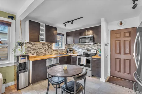 a kitchen with stainless steel appliances kitchen island granite countertop a refrigerator a stove a sink dishwasher and wooden cabinets with wooden floor