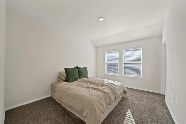 a bed sitting in a bedroom next to a window