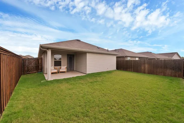 a backyard of a house with table and chairs