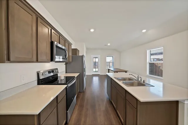a kitchen with a stove sink and cabinets