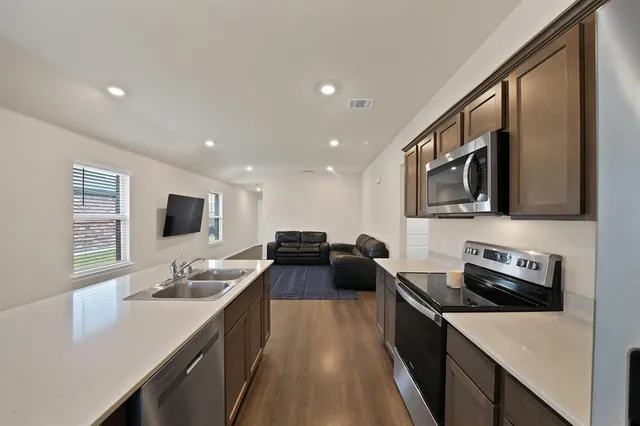 a kitchen with a sink stove and microwave