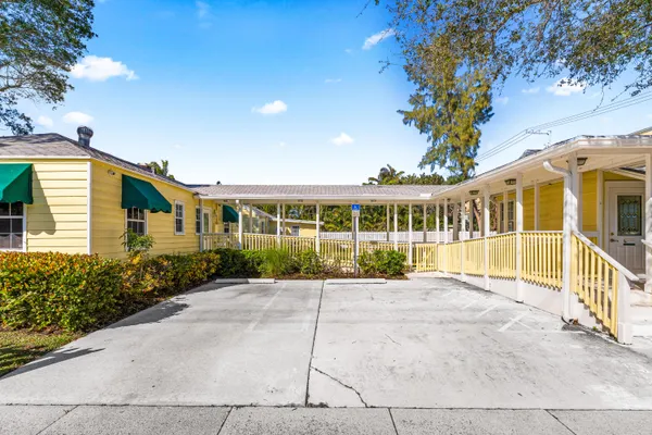 a view of a big house with a big yard and potted plants