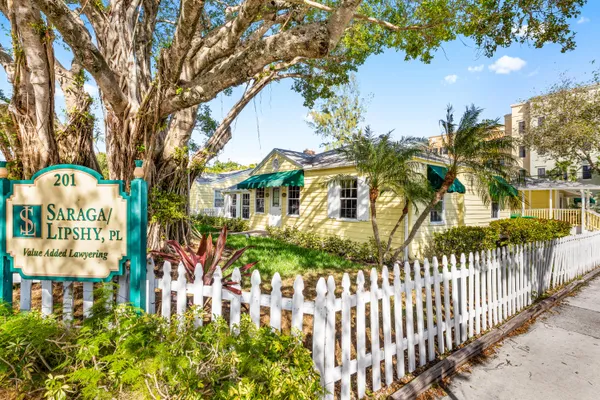 a view of a house with a small yard and wooden fence
