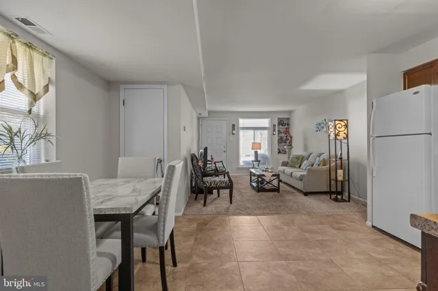 a living room with furniture and a refrigerator