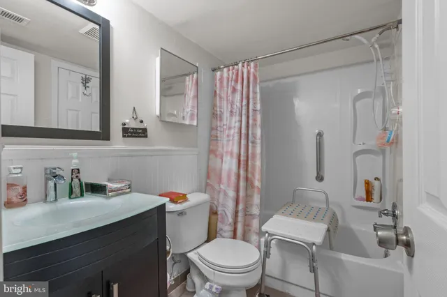 a bathroom with a sink toilet vanity and shower