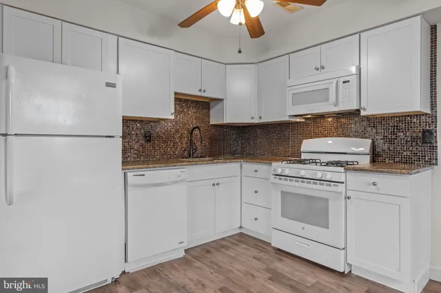 a kitchen with white cabinets and white appliances