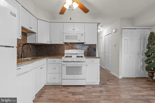 a kitchen with white cabinets and white appliances