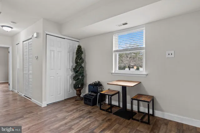 a view of a room with wooden floor lounge chair and windows