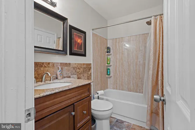 a bathroom with a granite countertop sink toilet and shower