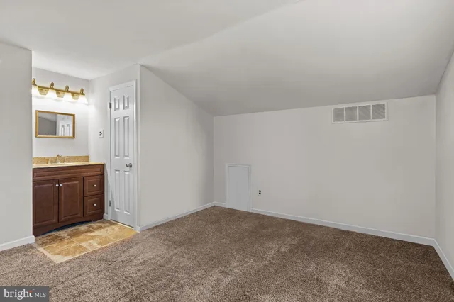 a view of an empty room and kitchen
