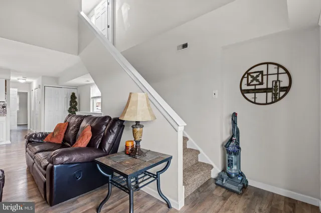 a living room with furniture a rug and white walls