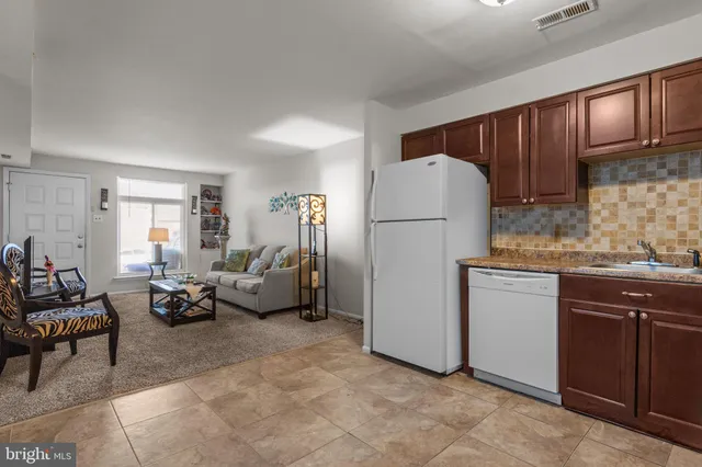 a living room with furniture and a refrigerator