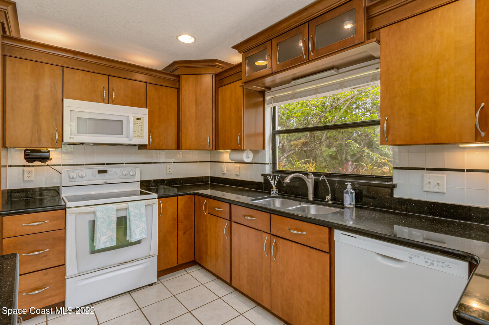 4650 Corey Road Grant Valkaria, FL 32950 - Photo 14 of 56 a kitchen with stainless steel appliances granite countertop a sink stove and cabinets