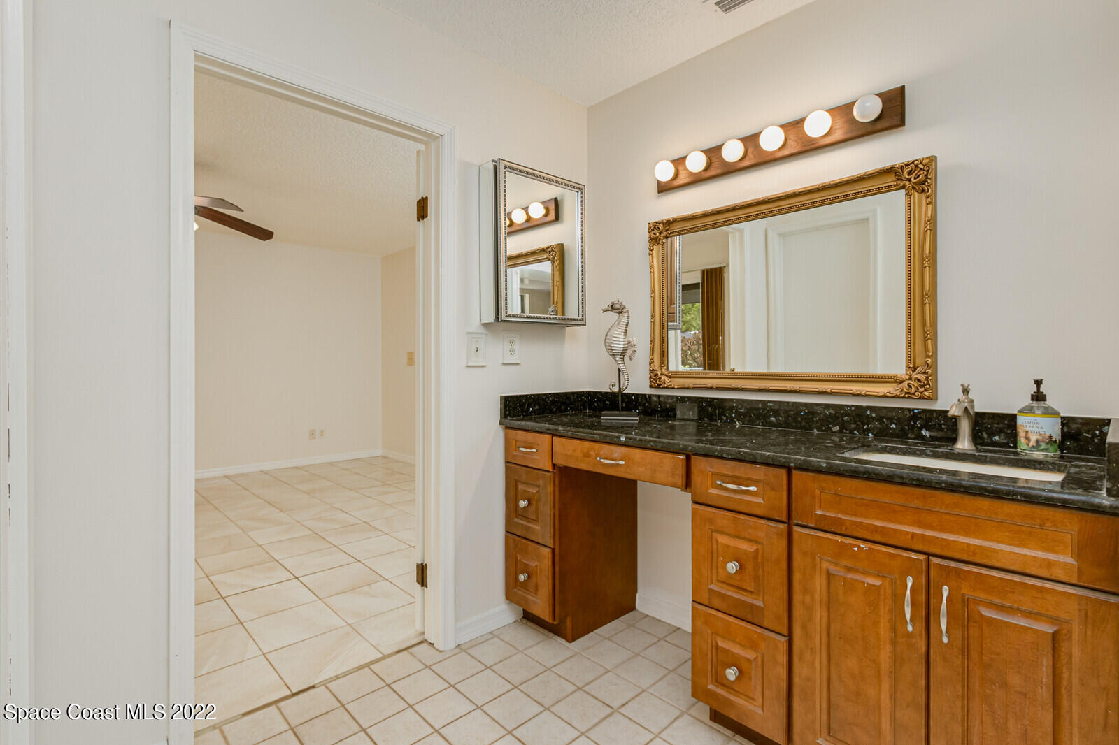 4650 Corey Road Grant Valkaria, FL 32950 - Photo 22 of 56 a bathroom with a granite countertop sink mirror and