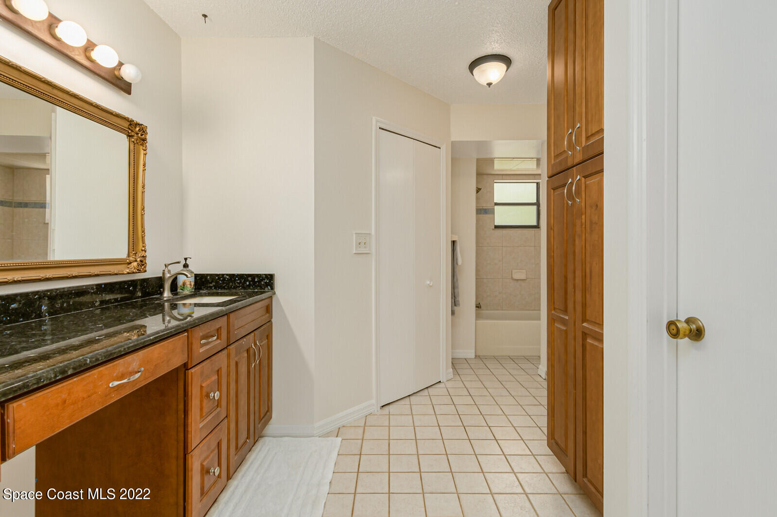 4650 Corey Road Grant Valkaria, FL 32950 - Photo 23 of 56 a bathroom with a granite countertop sink a mirror and a shower