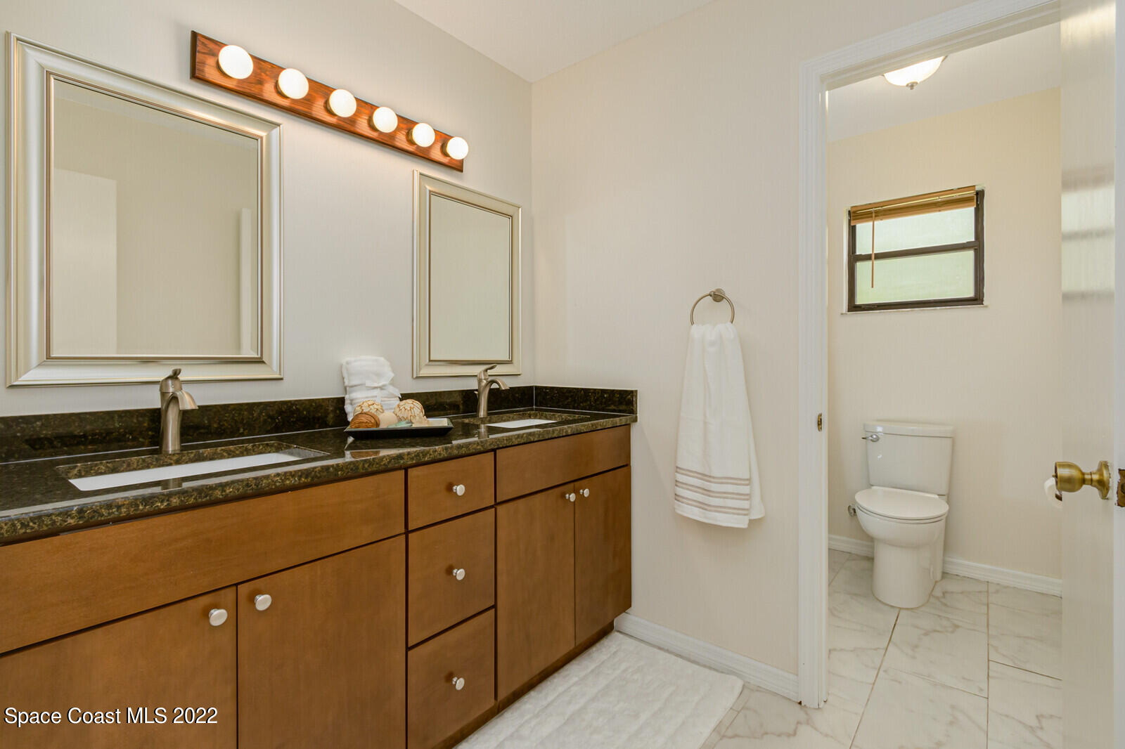4650 Corey Road Grant Valkaria, FL 32950 - Photo 26 of 56 a bathroom with a toilet sink and mirror