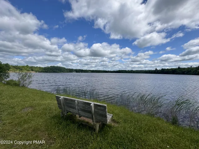 a view of a lake with outdoor seating and city view