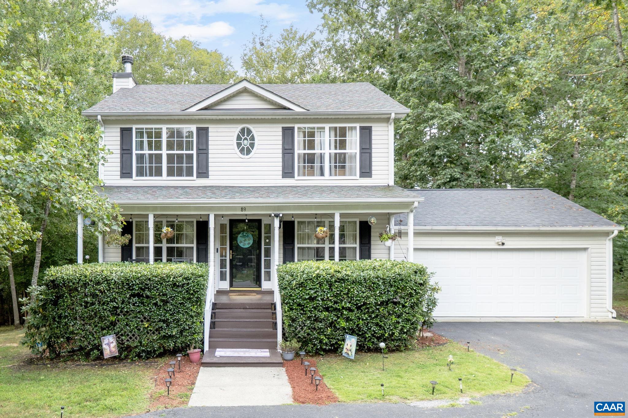 a front view of a house with a yard and potted plants