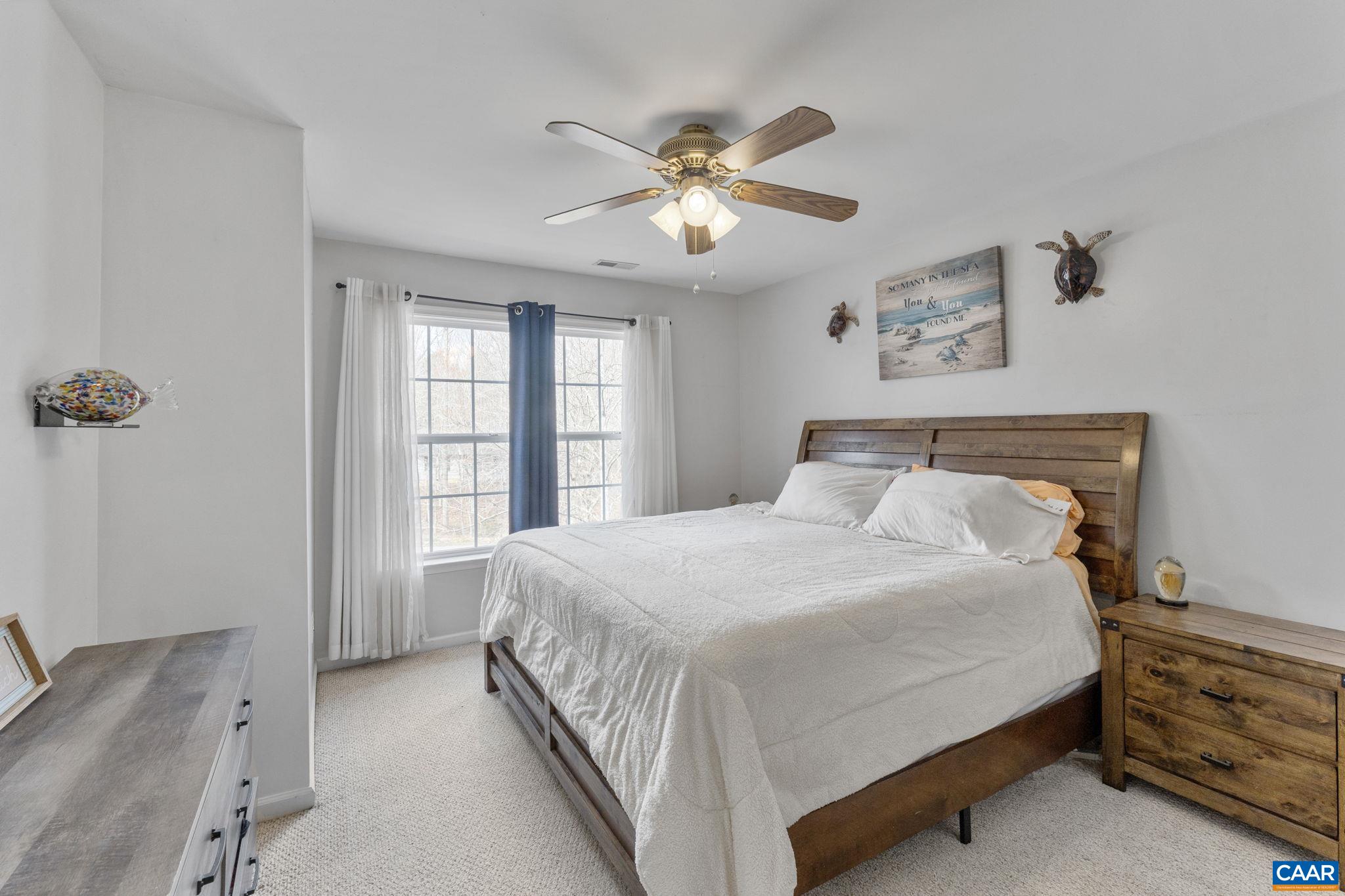 89 Riverside Drive Palmyra, VA 22963 - Photo 17 of 38 a bedroom with a large bed and a chandelier