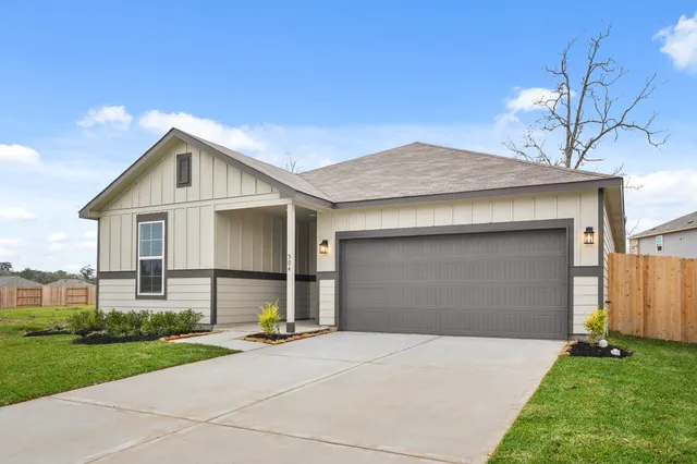 a view of a white house with a yard and large tree
