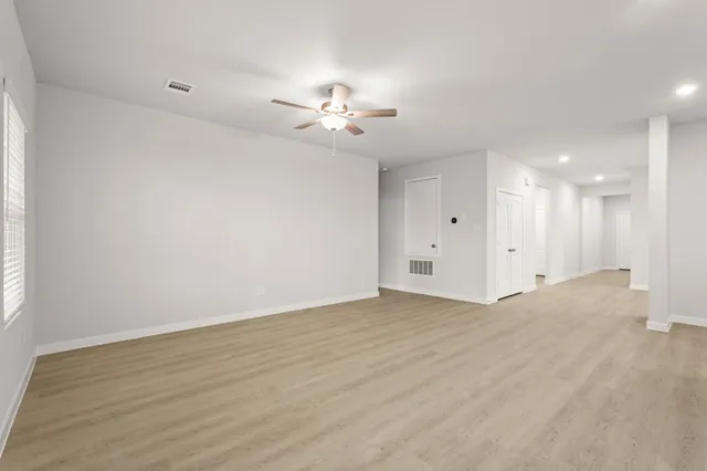 a view of an empty room with a ceiling fan