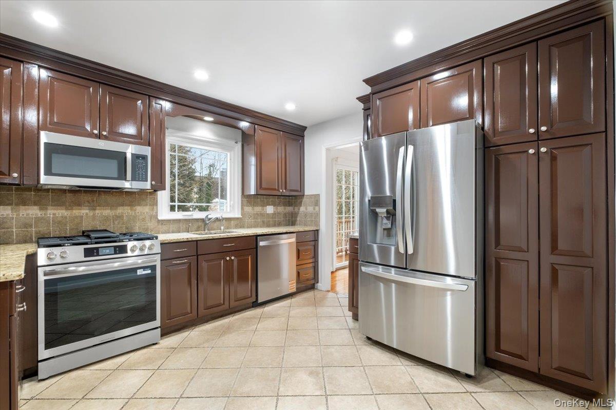 182 Madison Road Scarsdale, NY 10583 - Photo 12 of 30 a kitchen with granite countertop a refrigerator stove and microwave