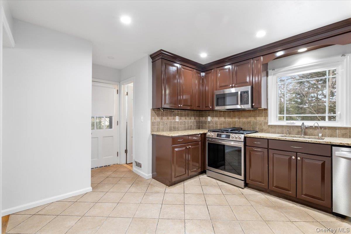 182 Madison Road Scarsdale, NY 10583 - Photo 13 of 30 a kitchen with stainless steel appliances granite countertop a refrigerator and a stove top oven