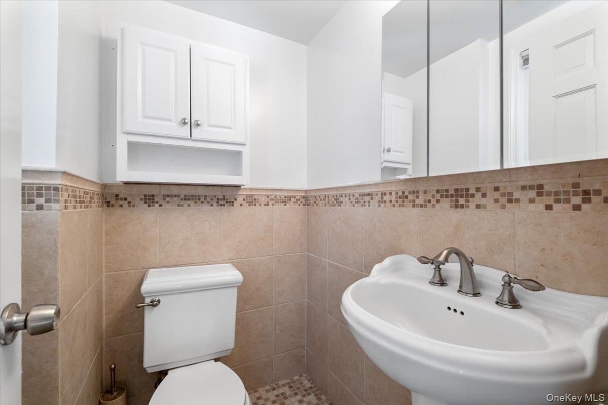 182 Madison Road Scarsdale, NY 10583 - Photo 15 of 30 a bathroom with a toilet a sink and mirror