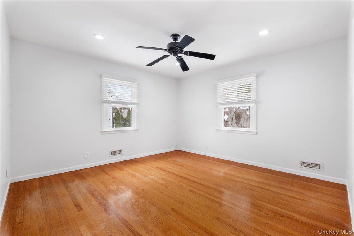 182 Madison Road Scarsdale, NY 10583 - Photo 18 of 30 an empty room with wooden floor ceiling fan and windows