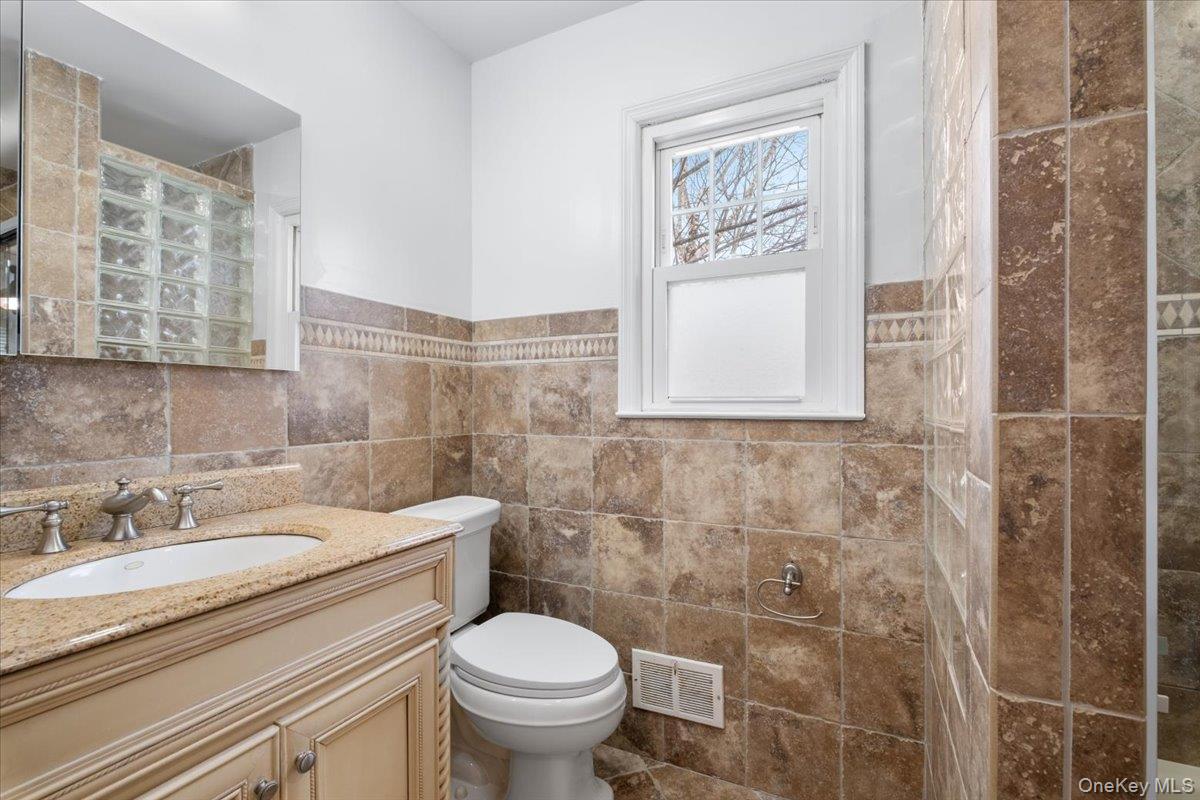 182 Madison Road Scarsdale, NY 10583 - Photo 21 of 30 a bathroom with a granite countertop sink a toilet and a shower