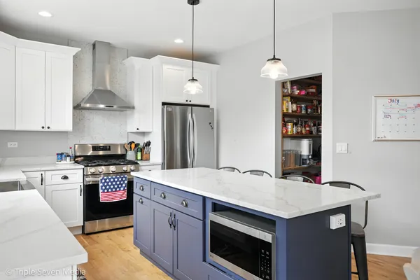 a kitchen with stainless steel appliances a stove a sink and a refrigerator