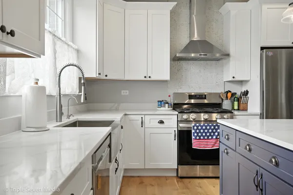 a kitchen with stainless steel appliances granite countertop a sink stove and cabinets