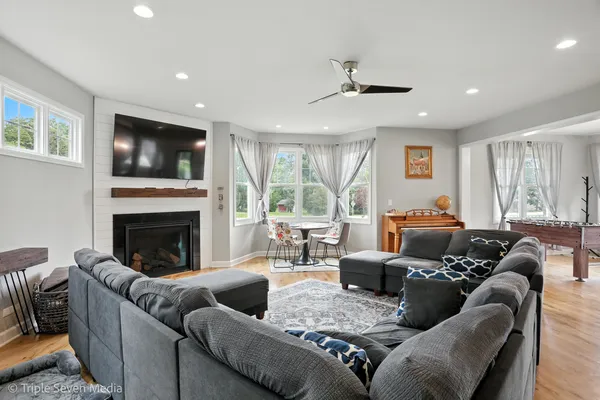 a living room with furniture large window and a fireplace
