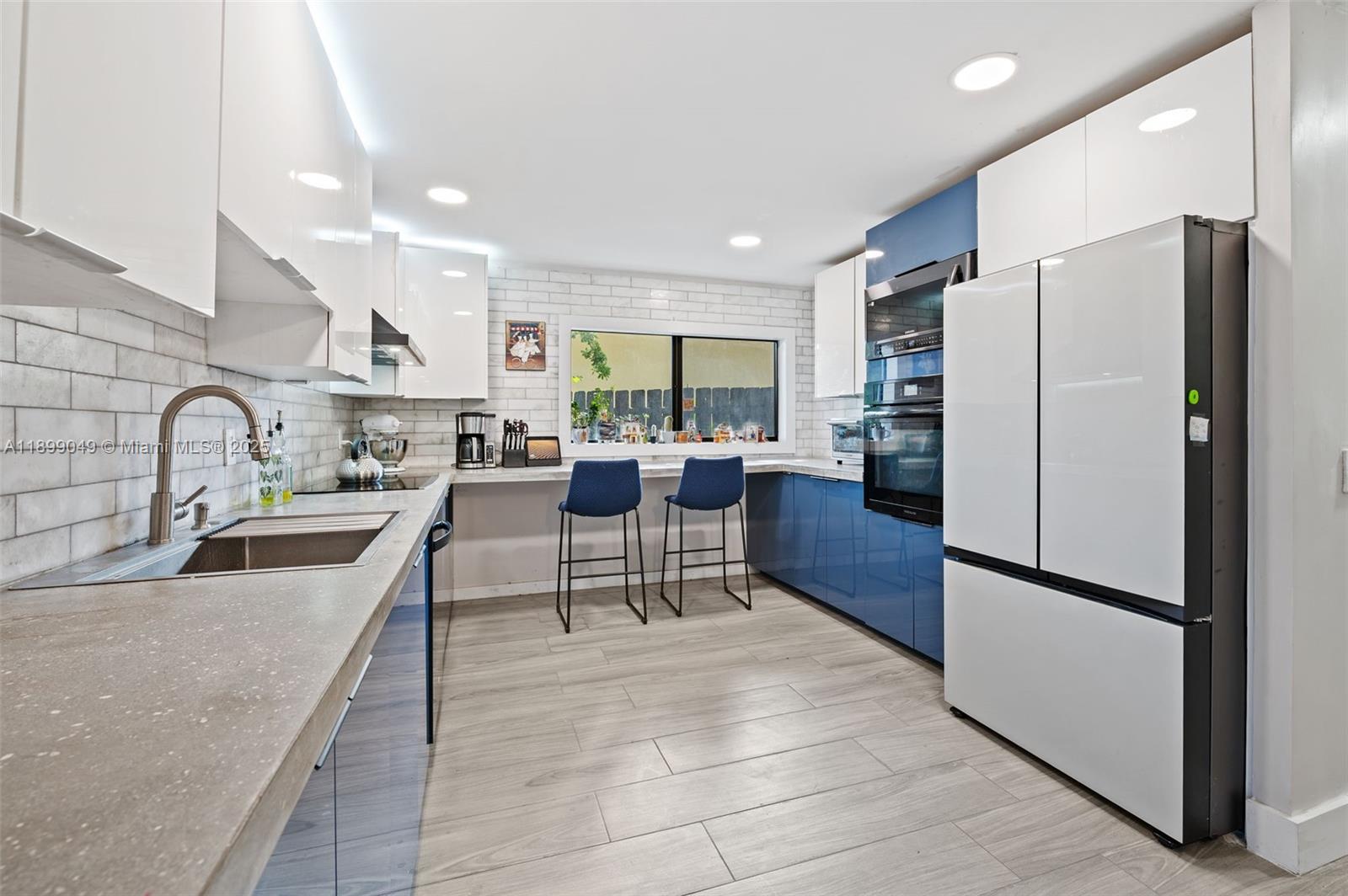 10923 Southwest 134th Court Miami, FL 33186 - Photo 6 of 28 a kitchen with stainless steel appliances granite countertop a refrigerator a sink a stove a dining table and chairs