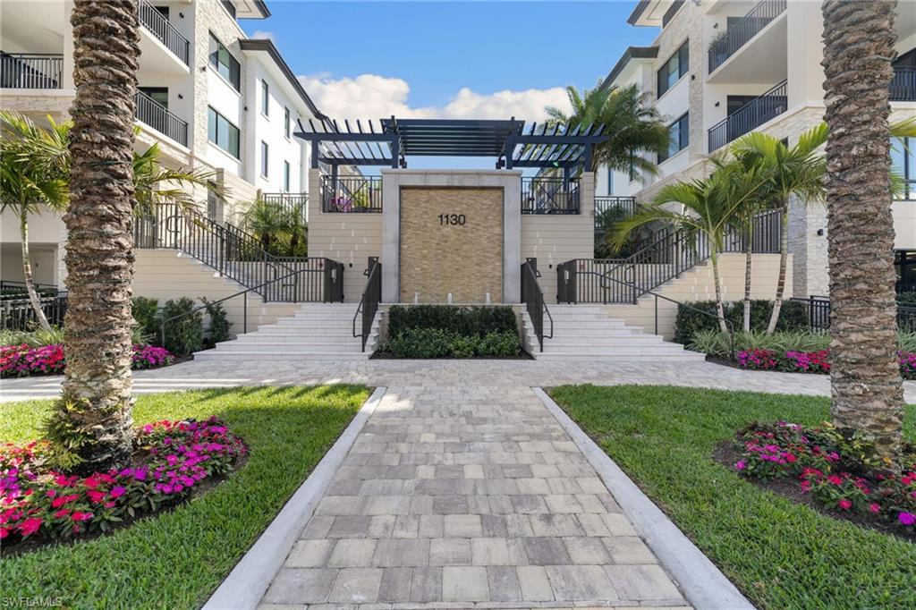 1130 3rd Avenue South, Unit 210 Naples, FL 34102 - Photo 1 of 48 a front view of a house with a garden