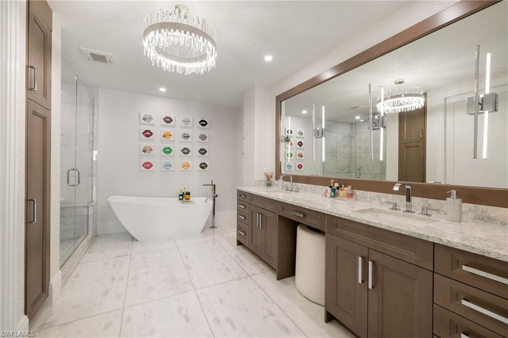 1130 3rd Avenue South, Unit 210 Naples, FL 34102 - Photo 19 of 48 a spacious bathroom with a bathtub sink and mirror