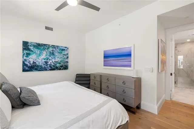 a bedroom with a bed and a painting on the wall