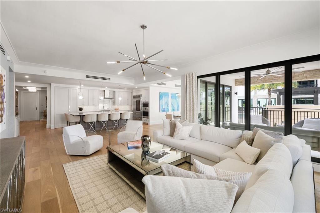 1130 3rd Avenue South, Unit 210 Naples, FL 34102 - Photo 6 of 48 a living room with furniture and a chandelier