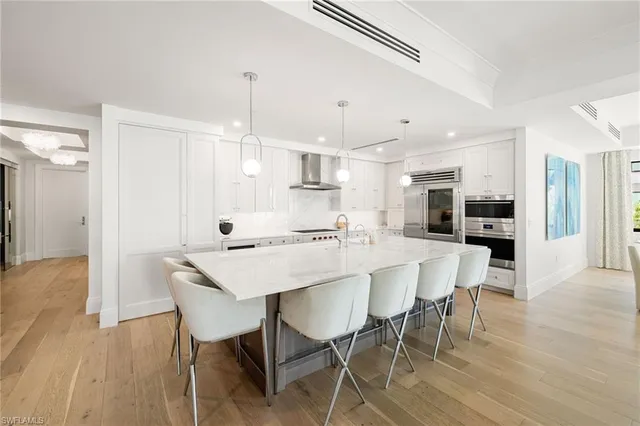 a view of a dining room and livingroom with furniture wooden floor a chandelier