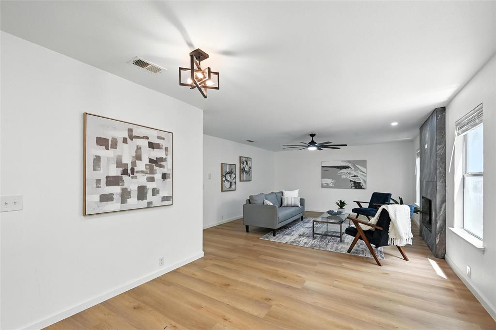 6218 Everglade Road Dallas, TX 75227 - Photo 12 of 39 Living room featuring light wood-style floors, a ceiling fan, and a chandelier