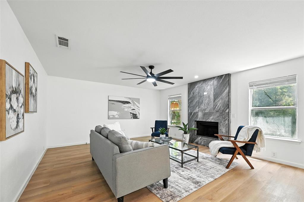 6218 Everglade Road Dallas, TX 75227 - Photo 17 of 39 Living room featuring healthy amount of natural light, wood finished floors, a high end fireplace, and a ceiling fan