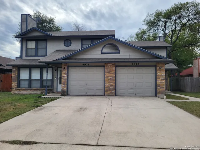 a front view of a house with a garden and garage