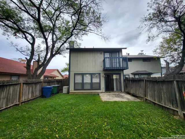 a view of a house with backyard and a tree
