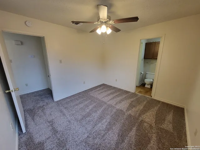 a view of a room with a chandelier fan and a window