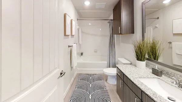 an empty room with wooden floor chandelier fan and windows