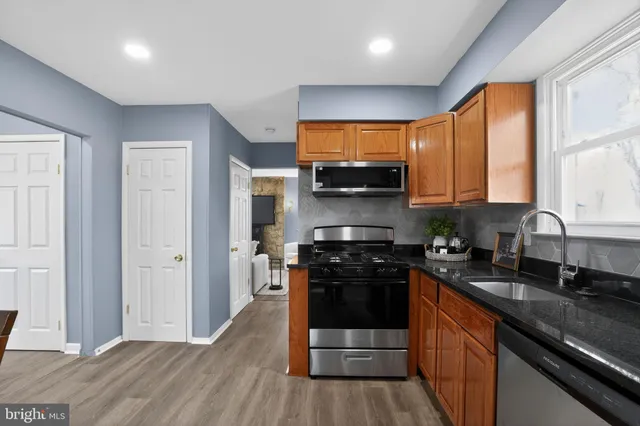 a kitchen with stainless steel appliances granite countertop a stove a sink and a refrigerator