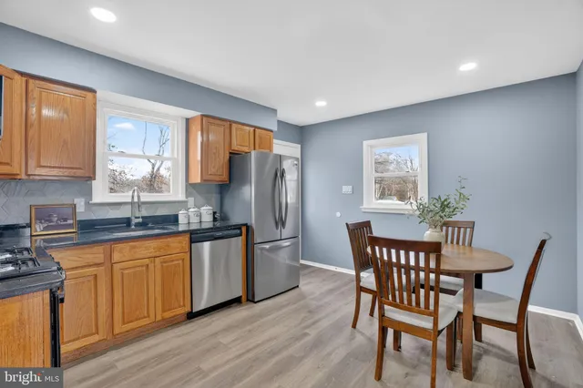 a kitchen with stainless steel appliances granite countertop a kitchen island hardwood floor sink and stove