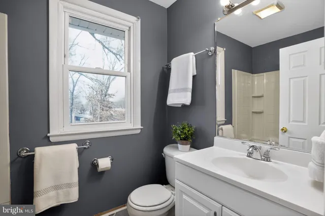 a bathroom with a sink vanity mirror and toilet